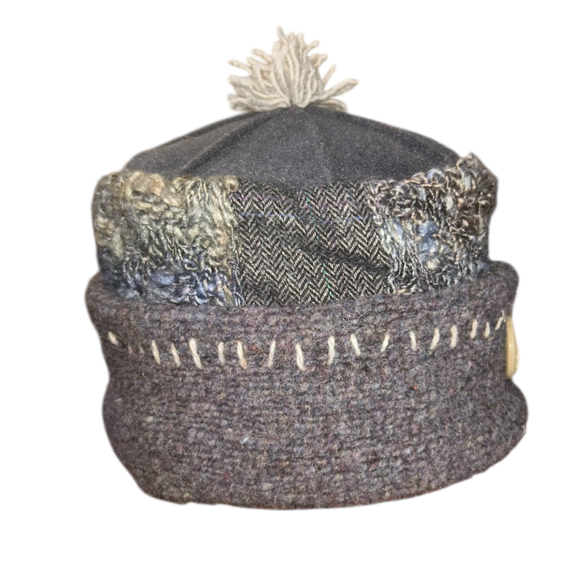 Textured knit beanie with patterned band and pom-pom on a white background