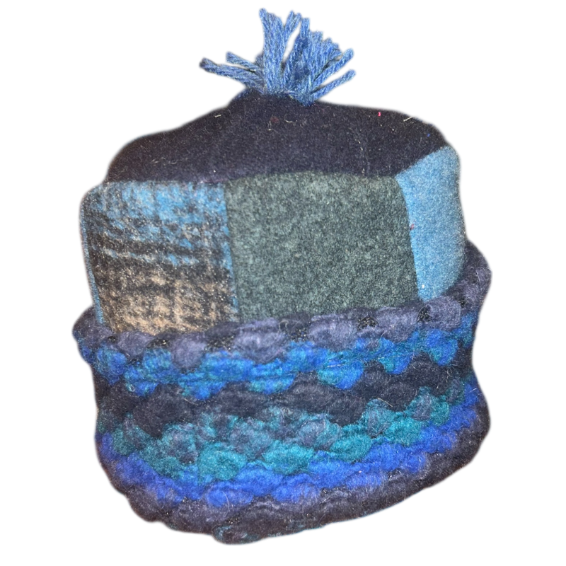 Knitted hat with a patchwork pattern in blue, green, and black on a white background